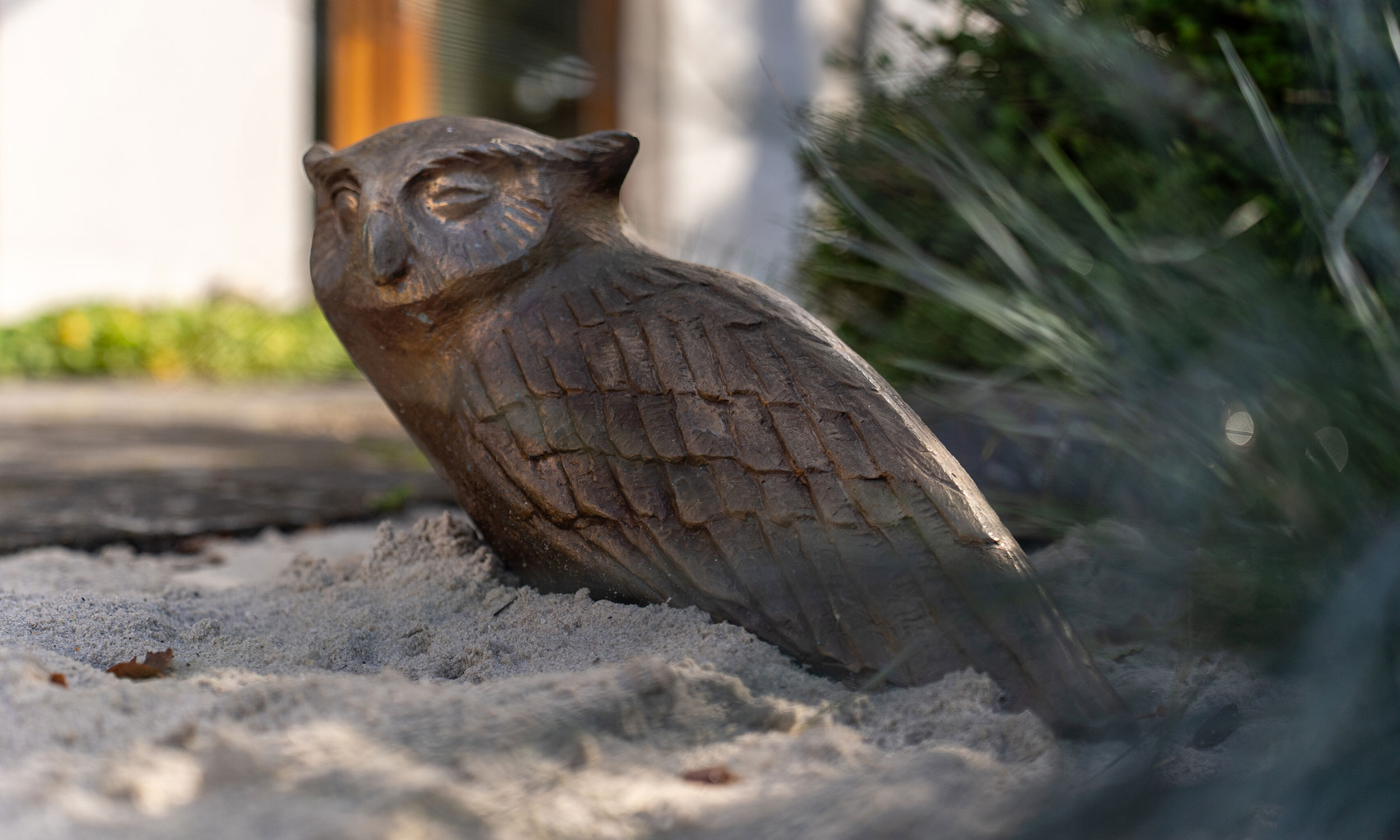 Das Bild zeigt die Figur einer Eule in den Au�enanlagen des Breipohls Hof