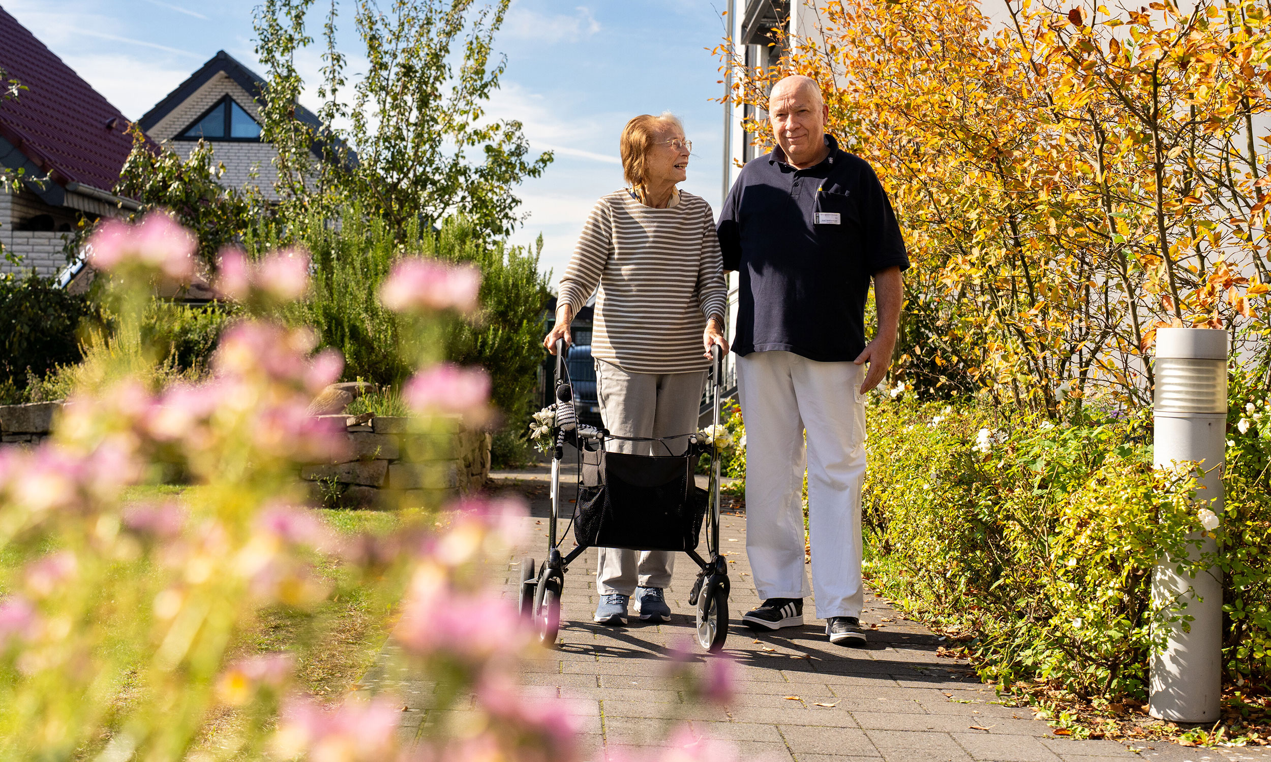 Eine Bewohnerin unternimmt mit einem Betreuer einen Spaziergang